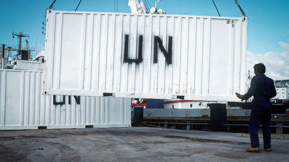 A civilian worker guides a UN container being unloaded from a ship during the multinational relief effort Operation Restore Hope